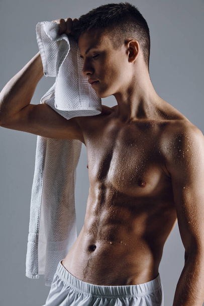αθλητικός αρσενικό bodybuilder αντλείται μέχρι πετσέτες κορμού - Φωτογραφία, εικόνα
