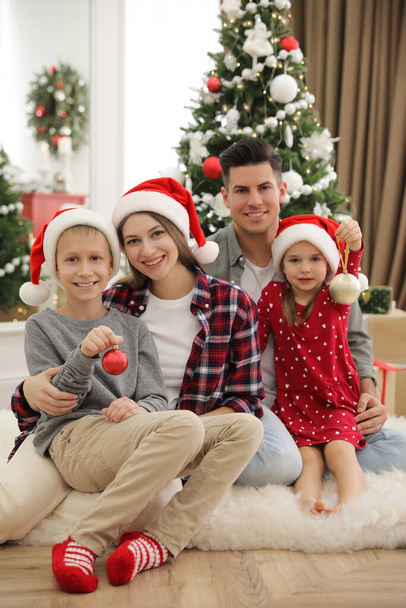 Famille heureuse avec des enfants mignons près de l'arbre de Noël ensemble à la maison - Photo, image