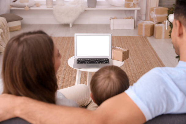 Rodina s dítětem pomocí video chatu na notebooku v pokoji zdobené na Vánoce, pohled zezadu - Fotografie, Obrázek