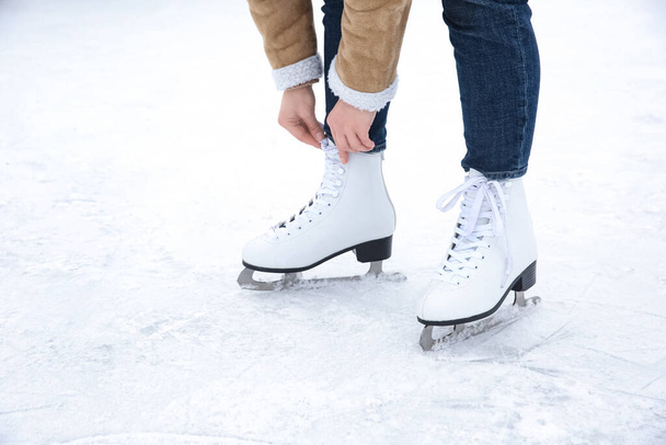 Woman lacing figure skate on ice rink, closeup - Foto, Imagem
