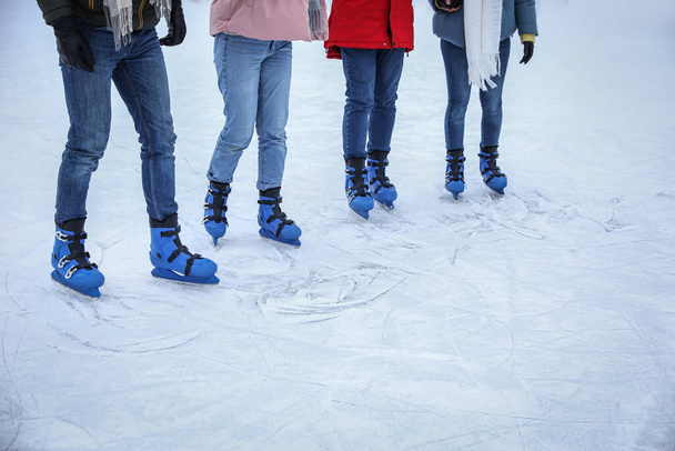 Amigos patinando a lo largo de pista de hielo al aire libre, primer plano. Espacio para texto - Foto, imagen