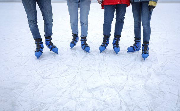 Friends at ice skating rink outdoors, closeup. Space for text - 写真・画像