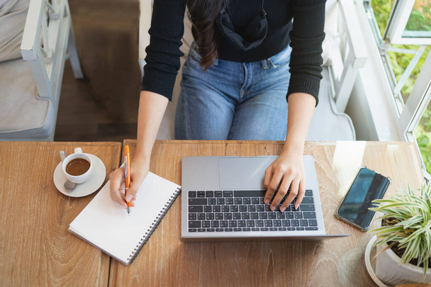 молодые женщины, работающие с ноутбуком на деревянном столе в кафе, бизнес-концепция - Фото, изображение