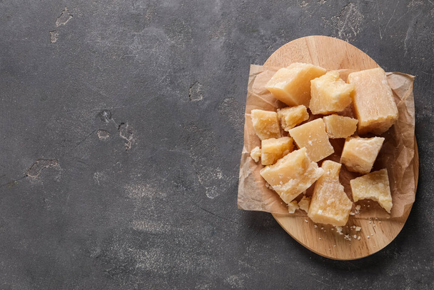 Pieces of delicious parmesan cheese on grey table, top view. Space for text - 写真・画像