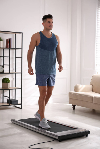 Sporty man training on walking treadmill at home - Фото, зображення