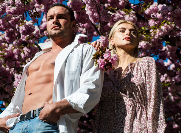 Sensual woman and man in pink flowers in summer blossom park. Man and woman. - Photo, Image