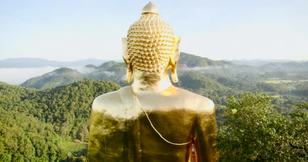 Golden Big buddha verde niebla de la colina en la cordillera en la mañana. Panorámica budista religión templo colina espalda vista gigante buda grande con hermoso mañana paisaje de montaña niebla y niebla cresta niebla - Imágenes, Vídeo