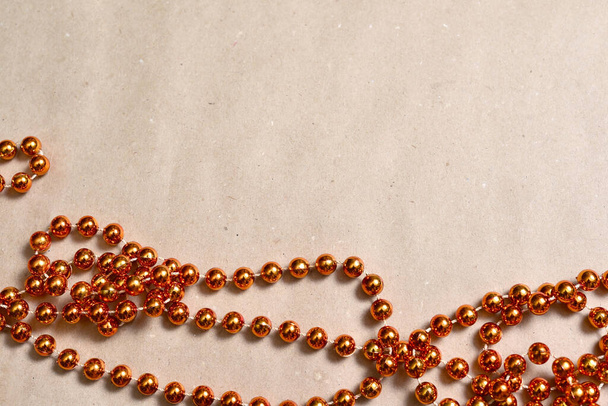 Sfondo in carta artigianale beige, fondo arancio perline rotonde per decorare l'albero di Natale. - Foto, immagini