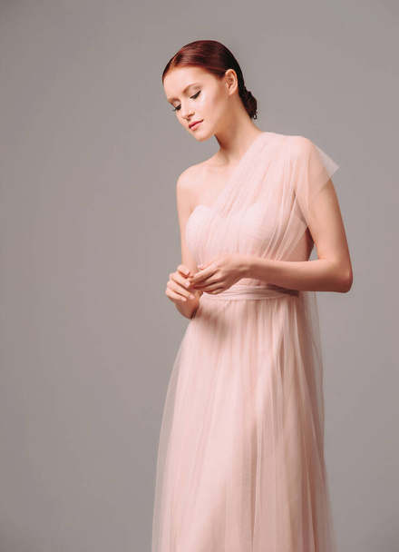 Elegant moscato dress with bow. Beautiful pink chiffon evening gown. Studio portrait of young brunette woman. Transformer dress idea for celebration. Bridesmaid dresses. - Foto, Imagem