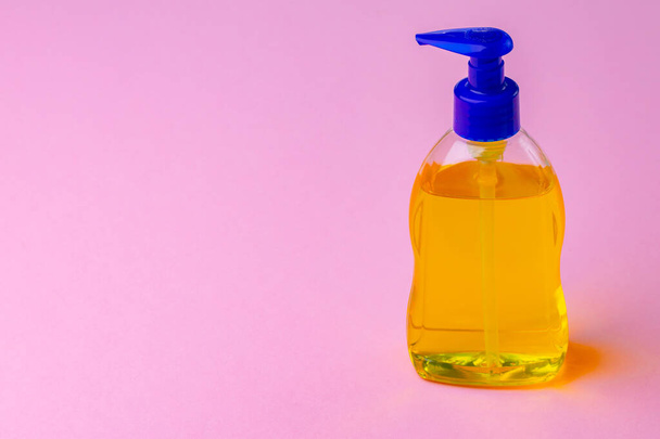 Bottle of liquid soap and hand sanitizer on pink background - Foto, Imagem