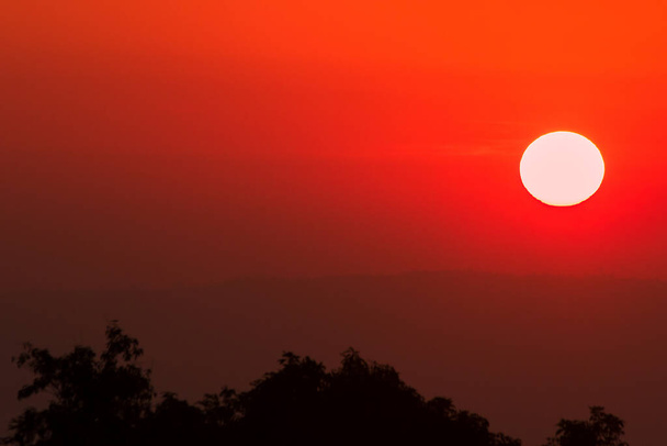 Die Landschaft der aufgehenden Sonne leuchtet orange über den Himmel. - Foto, Bild