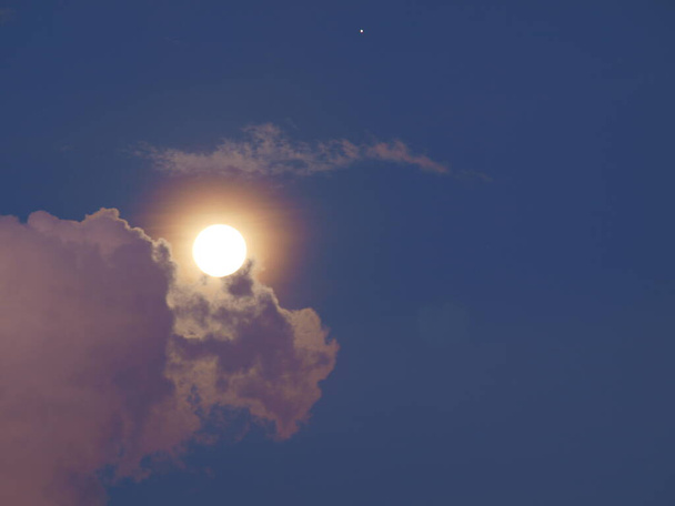 Выйдя из облаков, луна в сопровождении одной звезды - Фото, изображение