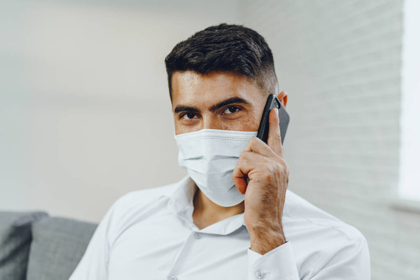 Handsome young businessman with face mask talking on the phone - Фото, зображення