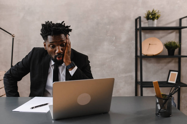 Black Businessman using laptop for analyzing data stock market, forex trading graph, stock exchange trading online. reaction to falling stocks - 写真・画像