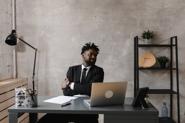 Focused black businessman in suit, holding video call with clients on laptop. Concentrated millennial man in suit giving online conference consulting customer - Foto, Imagem
