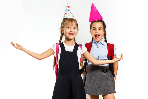 Conceitos divertidos da infância: duas pequenas alunas em chapéus de festa de aniversário - Foto, Imagem