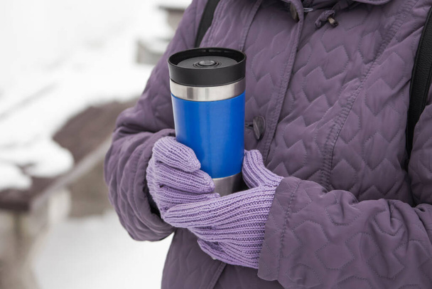 částečný pohled na ženu držící termoup s teplým nápojem v zimní den. - Fotografie, Obrázek