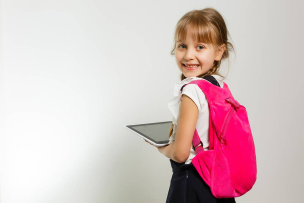 Egy kis vicces lány ingben. Elszigetelve, fehér háttérrel. Kislány az iskolában. A kislány a tankönyvekkel. Csajozás. - Fotó, kép