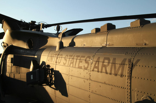 надпись "армия США" на фюзеляже военного вертолета на закате - Фото, изображение