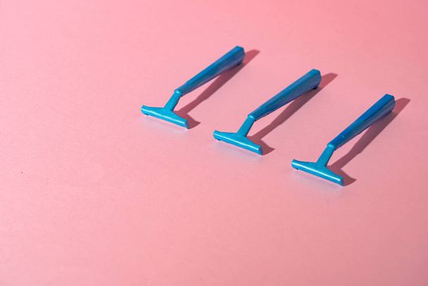 Blue disposable razors on pink paper background - Fotoğraf, Görsel