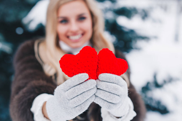 Two red knitting hearts in womens hands. Valentines day - Φωτογραφία, εικόνα