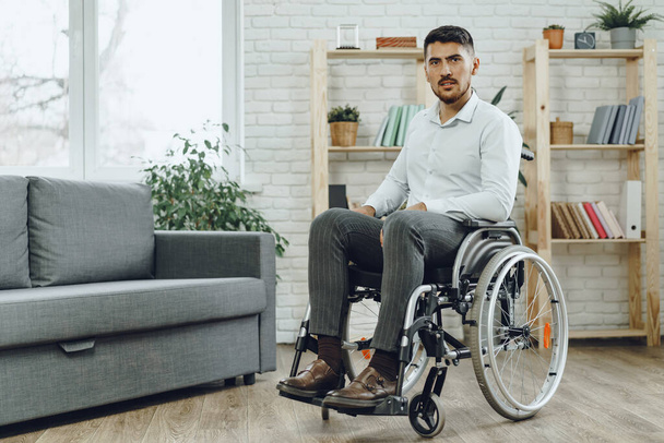 Portrait of disabled man in formal wear sitting in a wheelchair - Фото, зображення