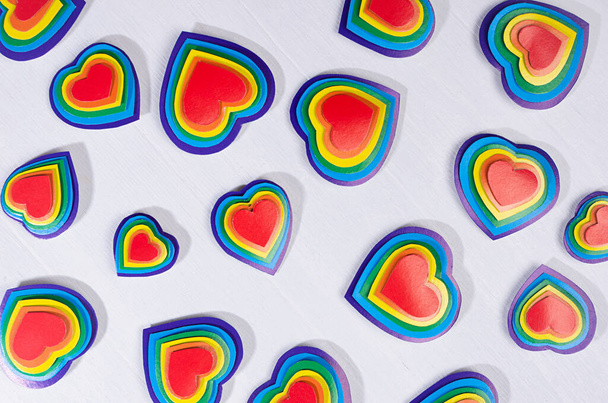 Festive lgbt background - multicolored valentines hearts as pattern on white wood board, top view. - Foto, Imagen