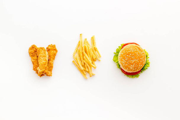 Fast food flat lay set. Burger with fried potatoes and chicken, top view - Foto, Imagem