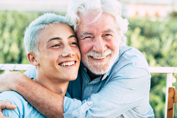 Vader en zoon of grootvader en kleinzoon samen knuffelen en genieten met een glimlach  - Foto, afbeelding