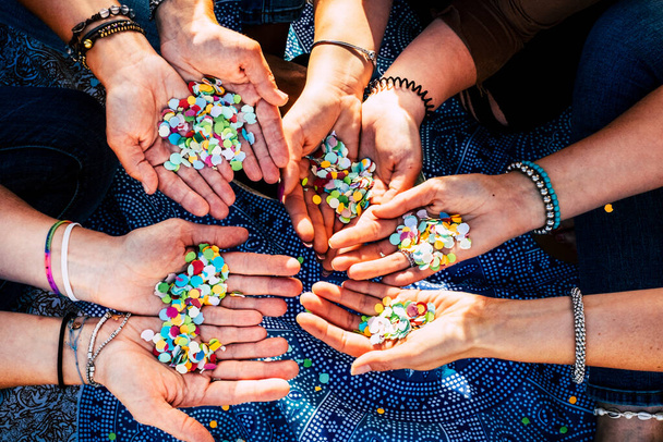 Close up of female hands full of confetti ready to celebrate together in friendship and team - Valokuva, kuva