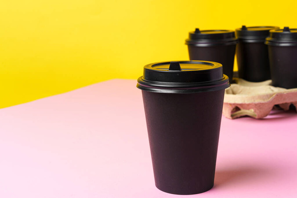 Black take away coffee cups in holder - Foto, afbeelding