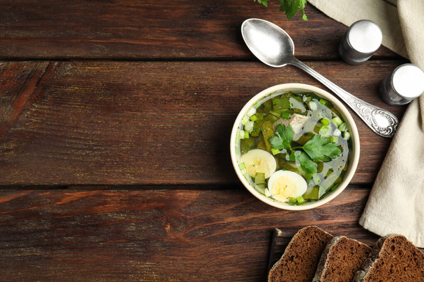 Delicious sorrel soup with eggs served on wooden table, flat lay. Space for text - Fotoğraf, Görsel