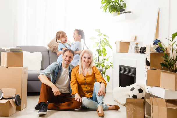 Familia feliz mudándose a casa con cajas alrededor - Foto, Imagen