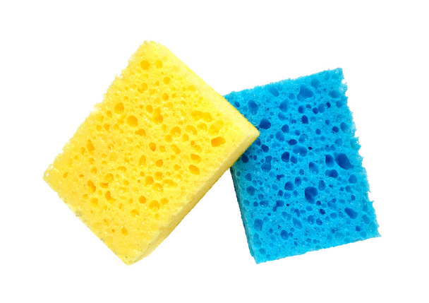 Esponjas de lavado porosas rectangulares azules y amarillas aisladas sobre un fondo blanco - Foto, imagen