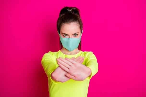 Photo portrait of girl wearing protective facial mask keeping hands in front showing stop isolated on vibrant fuchsia color background - Photo, image