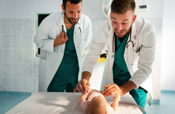 Happy pediatrician doctors examines baby. Healthcare, people, examination concept - Foto, afbeelding