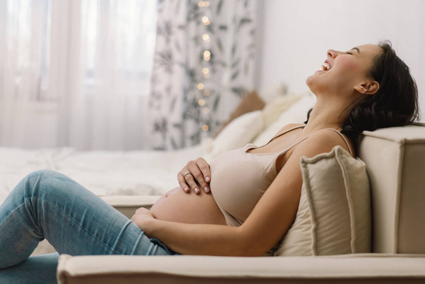 Счастливая очаровательная беременная женщина с помощью мобильного телефона. Беременная женщина. - Фото, изображение