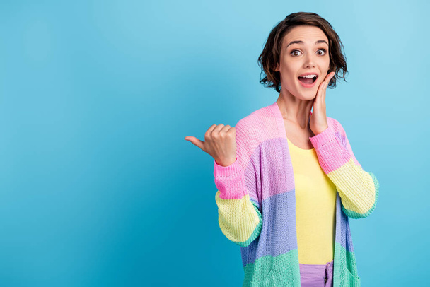 Photo portrait of excited girl with open mouth touching face cheek with hand pointing finger behind back at blank space isolated on pastel blue colored background - Φωτογραφία, εικόνα