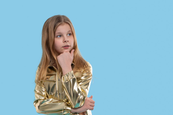 Портрет молодої блондинки в золотому комбінезоні на синьому фоні
 - Фото, зображення