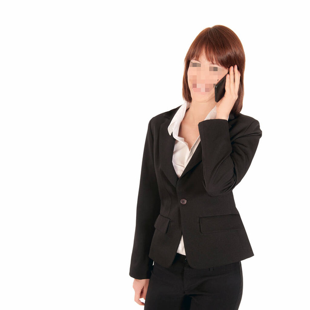Femme d'affaires avec visage pixellisé tenant un mobile, concept de protection de la vie privée des données, isolée sur fond de studio blanc - Photo, image