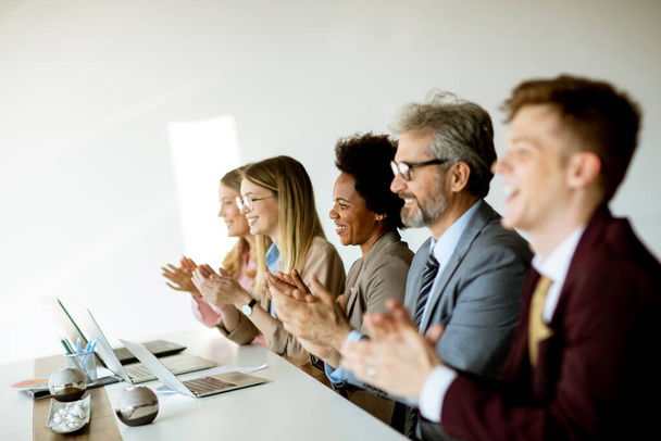 Groupe multiethnique de gens d'affaires travaillant ensemble et applaudissant après une réunion réussie au bureau - Photo, image