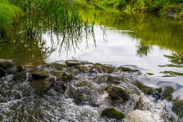 River flow over rocks in summer day. Waves of the river flow. Relaxing nature landscape scenics - Foto, Bild
