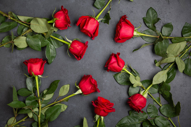 Beautiful red rose flowers on a black background. Top view, flatlay. - Fotó, kép