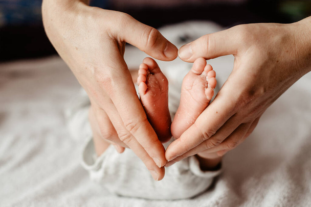 vauvan jalat pidetään äidin käsissä - Valokuva, kuva