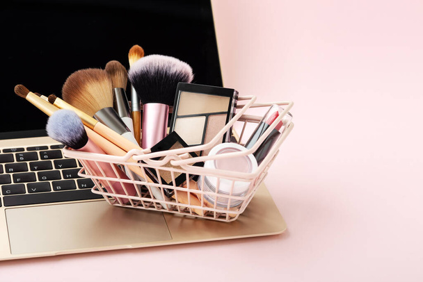 Maquillaje belleza compras en línea concepto de negocio sobre fondo rosa pastel con espacio de copia - Foto, imagen
