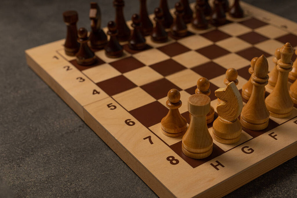 Chess pieces on a chessboard on a dark background - Photo, image