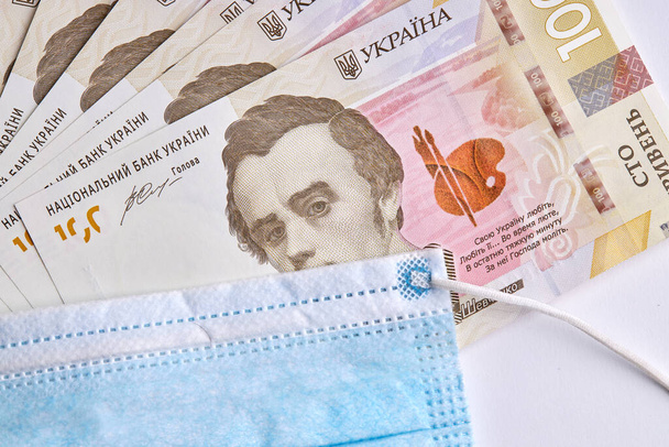 Украинская пандемия. защитная хирургическая маска на украинской бумажной валюте - Фото, изображение