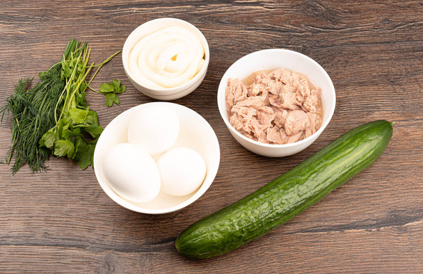 Ingredients for the tuna salad: canned tuna, eggs, cucumber, mayonnaise, dill and parsley. Top view. Close up. - Foto, Imagen