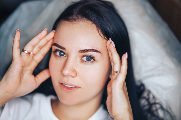 Junge Frau mit schönen Augenbrauen nach dem Eingriff Permanent Make-up im Salon, Nahaufnahme Foto. - Foto, Bild
