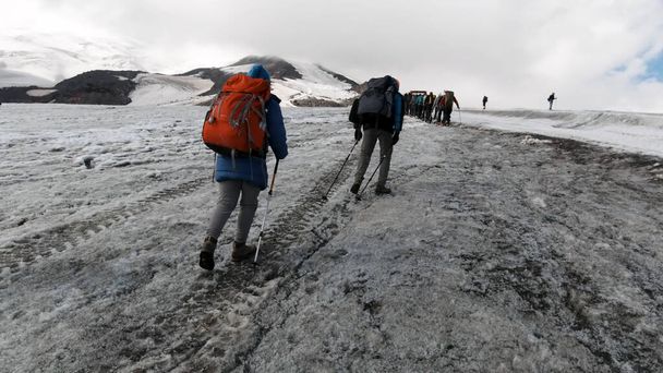 Tým horolezců stoupá po ledovém svahu na Mt. Everest přes oblohu. Klip. Lidé si užívají lezení po zasněžené stezce. - Fotografie, Obrázek